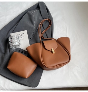 Détail d'un ensemble cabas en cuir marron avec pochette assortie et boucles dorées chic