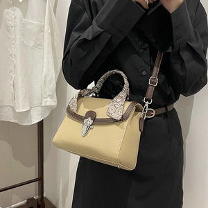 Elegant beige pebbled leather handbag with contrast trim and paisley scarf handle
