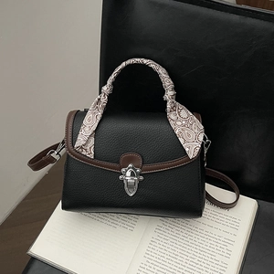 Black pebbled leather bag with contrast stitching and paisley scarf wrapped handle