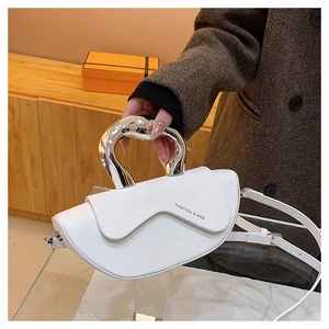 Détail du sac à main en cuir blanc avec poignée en métal argenté et bandoulière amovible