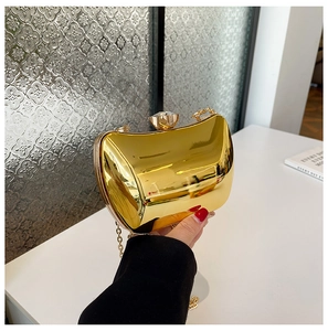 Detail of gold mirror clutch bag with jewel clasp and detachable metal chain