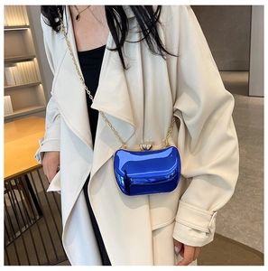 Detailed view of mirror blue evening clutch bag with golden chain on a trench coat