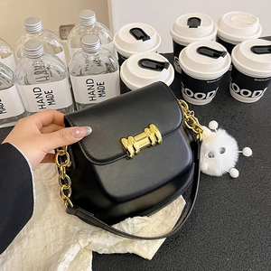 Elegante borsa a sella nera con catena dorata, fibbia in metallo e ciondolo morbido
