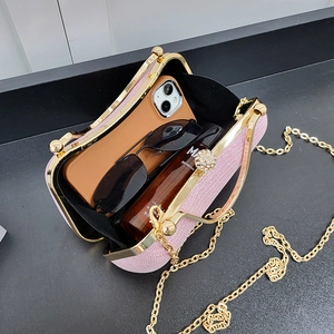 Pochette de soirée rose à paillettes avec chaîne dorée montrant la capacité interne