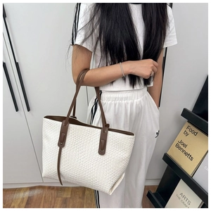 Dettaglio della trama intrecciata bianca e manici in pelle sulla borsa tote grande