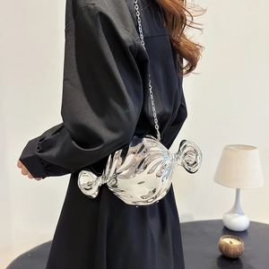 Chic silver candy-shaped metallic crossbody bag with chain strap shown on a model