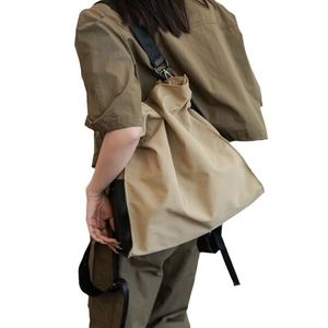 Canvas bucket bag with black strap in khaki tone, casual aesthetic for daily commute