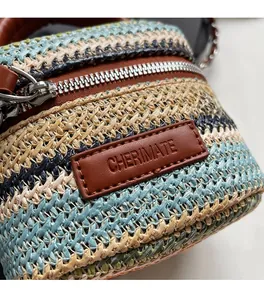 Close-up of multicolor woven straw bag featuring a leather logo tag and metal zipper