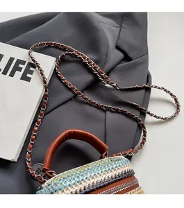 Detail of color-block mini straw bag with leather handle and metal chain strap