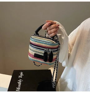 Detail of multi-colored woven mini bag with black leather handle and chain strap