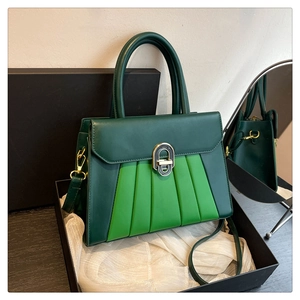 Détail du sac plissé vert avec fermoir rotatif en métal et bandoulière réglable
