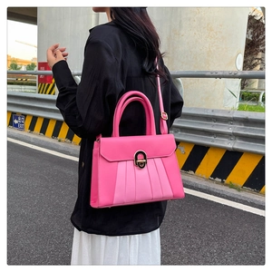 Détail du sac à bandoulière rose fuchsia avec design plissé et fermoir métallique doré