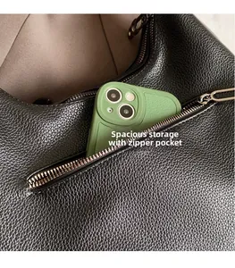 Detail of black pebbled leather handbag showing a spacious zipper pocket for a smartphone