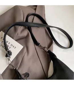 Detail of black lychee grain leather texture with adjustable shoulder strap and metal buckle