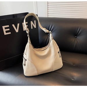 Close-up of beige hobo bag in litchi grain leather with creative silver paperclip zipper