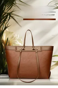 Detail of brown litchi grain leather tote with golden metal hardware and vintage design