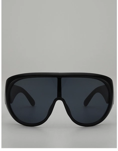 Close-up of oversized black shield sunglasses with a sleek glossy finish and seamless lens
