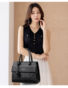 Close-up of black tote bag with geometric triangle embossing and elegant dual handles