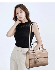 Detail of champagne gold tote bag featuring geometric quilted pattern and dual handles