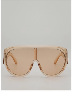 Macro detail of oversized champagne-colored shield sunglasses with translucent PC frames