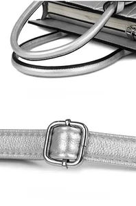 Detail view of the silver metallic handbag with round handles and adjustable metal strap buckle