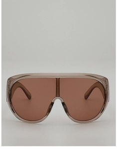 Detailed view of champagne shield sunglasses with gradient brown lenses and translucent frame