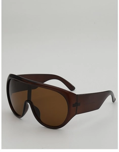Close-up of oversized dark brown shield sunglasses with high-gloss resin finish and wide temples