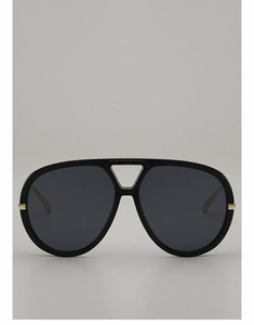 Close-up of black oversized aviator sunglasses with gold metal hinges and triangle cut-out