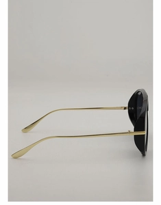 Close-up of sleek gold metal temples and hinge details of oversized aviator sunglasses