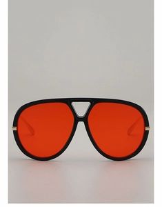 Detail of oversized aviator sunglasses featuring bright orange lenses and gold metal accents
