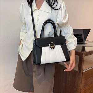 Sac à main minimaliste en cuir bicolore noir et blanc avec boucle dorée et plis accordéon