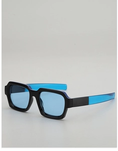 Detail view of square frame sunglasses with blue lenses and two-tone black blue arms