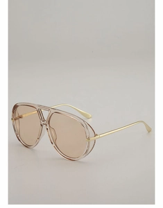 Detail of pilot sunglasses with translucent pink resin frame and gold metal temples