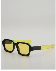 Detail view of stylish square sunglasses with green frames and yellow temples