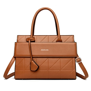 Brown leather tote bag with geometric triangle embossing and top handle detail