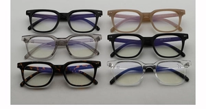 Detail view of stylish square eyeglass frames in various colors with metal rivet accents