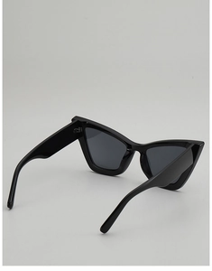Macro side view of trendy black cat-eye sunglasses with thick frames and UV protection