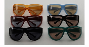 Flat lay of retro oversized mask sunglasses in six assorted vibrant colors and sleek design