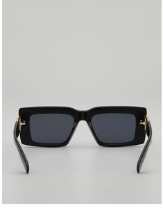 Détail de lunettes de soleil carrées noires avec charnière dorée et verres foncés