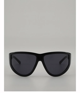 Detail of oversized shield sunglasses with glossy black frames and sleek dark lenses