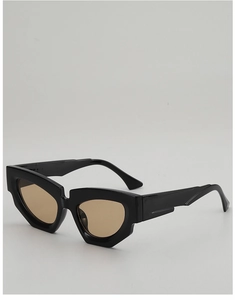 Detail of irregular black cat-eye sunglasses with thick frame and amber lenses