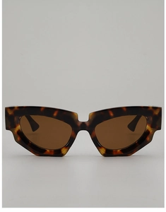 Close-up of tortoise shell cat eye sunglasses with thick frames and dark tea lenses