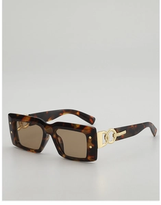 Détail de lunettes de soleil écaillées avec chaîne dorée et verres marron