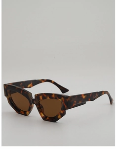 Detailed side view of irregular cat-eye sunglasses with thick tortoiseshell frames