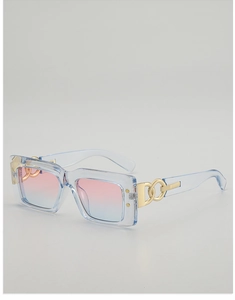 Détail de lunettes de soleil bleues rectangulaires avec verres dégradés et branches dorées