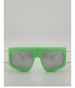 Detail of fashion large frame Y2K sunglasses in bright green with silver metal chain