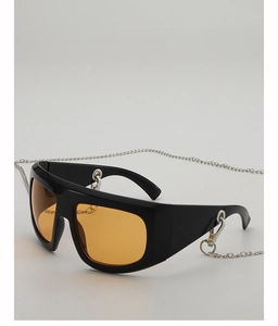 Detail of oversized black square sunglasses with amber lenses and silver metal chain strap