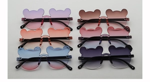 Flat lay of six cute bear-shaped kids sunglasses with colorful gradient resin lenses