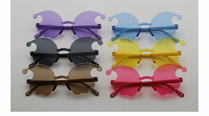 Flat lay of colorful rimless novelty sunglasses in six vibrant cartoon-inspired shapes