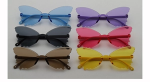 Flat lay of colorful butterfly-shaped rimless sunglasses for kids in six vibrant shades